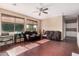 Open living room with rich hardwood floors, cozy brown couches, and natural light from large windows at 3680 S Tower Ave, Chandler, AZ 85286