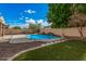 Beautiful pool with artificial waterfall feature in the backyard, complemented by lush artificial turf and desert landscaping at 3680 S Tower Ave, Chandler, AZ 85286