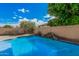 Serene pool with artificial waterfall feature surrounded by lush artificial turf and desert landscaping, creating a private oasis at 3680 S Tower Ave, Chandler, AZ 85286