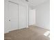 Bedroom with neutral carpet, closet with paneled doors, and white walls creating a spacious feel at 37357 W San Sisto Ave, Maricopa, AZ 85138