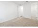 Bright bedroom with soft carpeting, white walls, and a doorway to the bathroom at 37357 W San Sisto Ave, Maricopa, AZ 85138