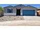 Charming single-story home featuring a blue garage door, neutral color scheme, and low-maintenance front yard at 37357 W San Sisto Ave, Maricopa, AZ 85138