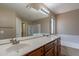 Bathroom with double sinks, wood cabinets, and separate bathtub at 3765 E Oxford Ln, Gilbert, AZ 85295