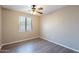 Neutral bedroom with gray wood-look flooring, ceiling fan, and large window at 3765 E Oxford Ln, Gilbert, AZ 85295