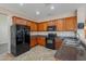 Kitchen with wood cabinets, black appliances, and tile backsplash at 3765 E Oxford Ln, Gilbert, AZ 85295