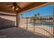 A covered patio with wrought iron fence overlooks a refreshing pool and tropical landscaping at 3765 E Oxford Ln, Gilbert, AZ 85295
