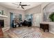Spacious living room with stone fireplace, modern furniture, and natural light at 43121 W Sunland Dr, Maricopa, AZ 85138
