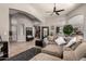 Open-concept living room with comfortable sectional seating and views into the kitchen at 43121 W Sunland Dr, Maricopa, AZ 85138