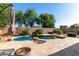 Resort style pool with rock waterfall feature and mature landscaping on a bright sunny day at 43121 W Sunland Dr, Maricopa, AZ 85138