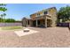 Large backyard with an outdoor fire pit, gravel, and green grass at 4322 S Ranger Trl, Gilbert, AZ 85297