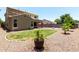Desert landscaped backyard with mature trees and a lawn area at 4322 S Ranger Trl, Gilbert, AZ 85297