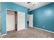 Bedroom with blue walls featuring closet and bathroom doors, with carpeted floors and ceiling fan at 4322 S Ranger Trl, Gilbert, AZ 85297