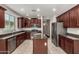 Well-appointed kitchen with stainless steel appliances, granite countertops, tile flooring, and dark wood cabinets at 4322 S Ranger Trl, Gilbert, AZ 85297
