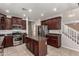 Kitchen features stainless steel appliances, granite countertops, tile flooring, and a view of the stairs at 4322 S Ranger Trl, Gilbert, AZ 85297