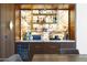 This custom bar features illuminated onyx backsplash, display shelving, beverage fridge, and marble countertops at 4763 N 53Rd St, Phoenix, AZ 85018