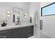 Modern bathroom with a gray vanity, a large mirror, and a glass-enclosed shower at 4763 N 53Rd St, Phoenix, AZ 85018