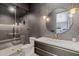 Modern bathroom features a glass enclosed shower, round mirror with gold accents, and geometric patterned walls at 4763 N 53Rd St, Phoenix, AZ 85018