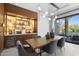 A dining room features an illuminated bar, modern lighting, neutral decor, and an adjacent outdoor living space at 4763 N 53Rd St, Phoenix, AZ 85018