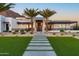A modern home's front exterior with a green lawn, landscaped entryway, and striking palm trees at 4763 N 53Rd St, Phoenix, AZ 85018