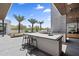 An outdoor kitchen boasts a built-in grill, bar seating, and views of the sports court surrounded by lush greenery and palm trees at 4763 N 53Rd St, Phoenix, AZ 85018