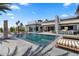 Resort-style pool with lounge chairs, outdoor kitchen, and stylish seating, with modern architectural details under a blue sky at 4763 N 53Rd St, Phoenix, AZ 85018