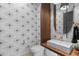 A stylish powder room featuring modern fixtures, unique wallpaper, and wood slat accents at 4763 N 53Rd St, Phoenix, AZ 85018