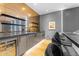 Contemporary wet bar with mirrored backsplash, sleek cabinets, and barstool seating at 4763 N 53Rd St, Phoenix, AZ 85018