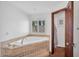 Bright bathroom showcasing a modern soaking tub, tile surround, and shuttered window at 5307 N 32Nd Pl, Phoenix, AZ 85018