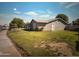 View of side yard featuring mature trees, a grass lawn, and a block wall fence at 6111 N 64Th Dr, Glendale, AZ 85301
