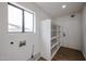 Well-lit laundry room with a window, shelving, and a door at 619 N Norfolk --, Mesa, AZ 85205