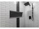 Stand-up shower with white tile walls, black accents, and a built-in shower niche at 6610 E University Dr # 165, Mesa, AZ 85205