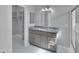 Modern bathroom with granite countertop vanity, vanity lights, and tile flooring with a walk-in closet at 6752 W Citrus Way, Glendale, AZ 85303