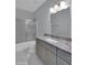 Bathroom with gray cabinets, granite countertop, silver faucet, shower tub and marble floors at 6752 W Citrus Way, Glendale, AZ 85303