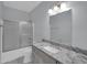 Bathroom with a gray vanity, granite countertop, silver faucet and a shower tub with sliding glass doors at 6752 W Citrus Way, Glendale, AZ 85303