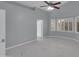Bedroom features a ceiling fan, light gray walls and flooring, and large windows at 6752 W Citrus Way, Glendale, AZ 85303