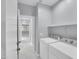 Well-lit laundry area with side-by-side machines, shelving, and hall access at 6752 W Citrus Way, Glendale, AZ 85303