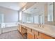 Bright bathroom with double sink vanity, large mirror, and soaking tub at 6833 W Tether Trl, Peoria, AZ 85383