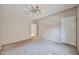 Carpeted bedroom with ceiling fan, window, and walk-in closet entrance at 6833 W Tether Trl, Peoria, AZ 85383