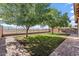 Backyard with green grass, a brick walkway, a block wall, and a wrought iron fence with mountain views at 7818 S 74Th Ave, Laveen, AZ 85339