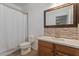 Well-lit bathroom featuring a shower, toilet, vanity with stylish mirror and backsplash at 7818 S 74Th Ave, Laveen, AZ 85339