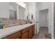 Bathroom featuring a long vanity with ample storage space and a large mirror, with tile accent backsplash at 7818 S 74Th Ave, Laveen, AZ 85339