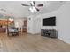 Open-concept living room with wood-style flooring, large TV, and dining area at 7818 S 74Th Ave, Laveen, AZ 85339