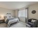 A styled bedroom with a bed and an accent chair with ottoman at 9814 W Long Hills Dr, Sun City, AZ 85351