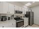 Well-equipped kitchen with updated appliances, white cabinets, and a bright overhead light at 9814 W Long Hills Dr, Sun City, AZ 85351