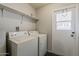 Functional laundry room with a washer and dryer, along with an exterior door at 9814 W Long Hills Dr, Sun City, AZ 85351