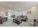 Open-concept living area with neutral carpet, stylish furniture, and a dining area nearby at 9814 W Long Hills Dr, Sun City, AZ 85351