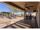 Spacious covered patio with ceiling fan, outdoor seating, and barbecue area, perfect for entertaining in the landscaped backyard at 9998 W Prospector Dr, Queen Creek, AZ 85144