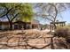 Expansive backyard featuring a water fountain, outdoor kitchen, pergola, seating around a fire pit, and mature landscaping at 9998 W Prospector Dr, Queen Creek, AZ 85144