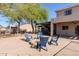 Backyard oasis featuring a cozy fire pit area with Adirondack chairs, barbecue, water fountain, and relaxing outdoor space at 9998 W Prospector Dr, Queen Creek, AZ 85144