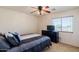 Bright bedroom with queen bed, dark wood dresser, and a ceiling fan at 9998 W Prospector Dr, Queen Creek, AZ 85144